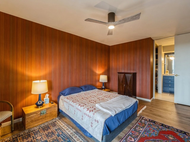 3663 Grand Ave Unit 508, Des Moines, IA 50312 - bedroom with wood finished floors, wooden walls, a ceiling fan, and baseboards