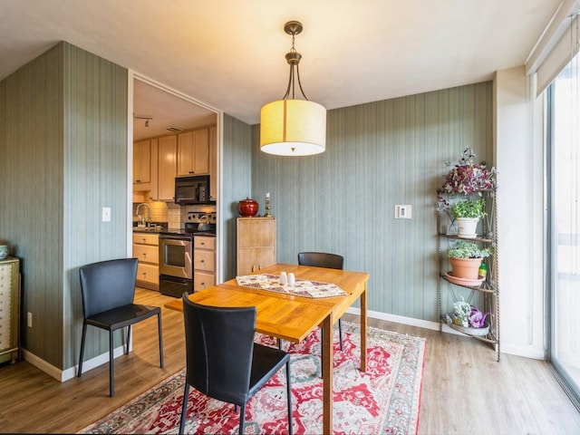 3663 Grand Ave Unit 508, Des Moines, IA 50312 - dining area featuring light wood-type flooring, wallpapered walls, and baseboards