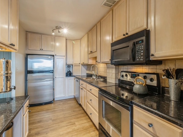 3663 Grand Ave Unit 508, Des Moines, IA 50312 - kitchen with stainless steel appliances, a sink, light brown cabinetry, decorative backsplash, and light wood-style flooring
