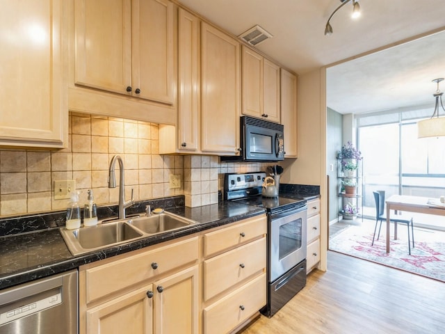 3663 Grand Ave Unit 508, Des Moines, IA 50312 - kitchen with appliances with stainless steel finishes, a sink, light brown cabinets, dark countertops, and decorative backsplash