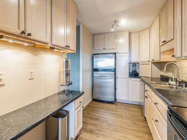 3663 Grand Ave Unit 508, Des Moines, IA 50312 - kitchen with stainless steel appliances, a sink, backsplash, light wood finished floors, and baseboards