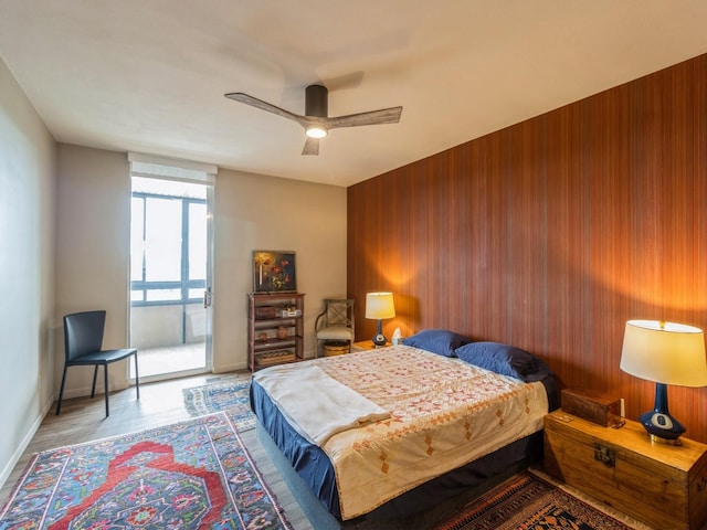 3663 Grand Ave Unit 508, Des Moines, IA 50312 - bedroom with baseboards, wood walls, ceiling fan, and access to exterior