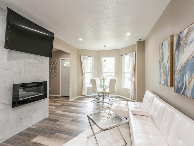 2917 2nd Ave, Des Moines, IA 50313 - living area featuring wood finished floors, a textured ceiling, a tile fireplace, recessed lighting, and baseboards