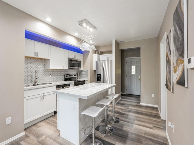 2917 2nd Ave, Des Moines, IA 50313 - kitchen with appliances with stainless steel finishes, a sink, white cabinets, tasteful backsplash, and recessed lighting