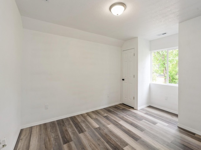 2917 2nd Ave, Des Moines, IA 50313 - spare room featuring wood finished floors, baseboards, and a textured ceiling