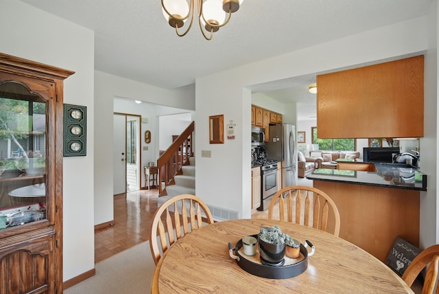 1011 NE 60th Ave, Des Moines, IA 50313 - dining room with a chandelier, stairs, and baseboards