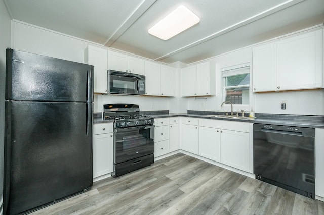 2409 45th St, Des Moines, IA 50310 - kitchen with black appliances, dark countertops, and white cabinetry