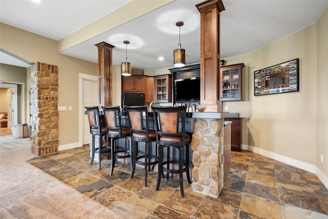 2492 55th St, Vinton, IA 52349 - indoor bar with ornate columns, stone tile floors, fridge, baseboards, and recessed lighting
