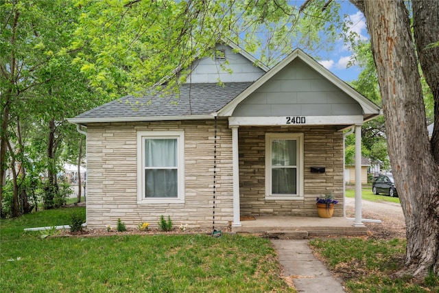 2400 Capitol Ave, Des Moines, IA 50317 - bungalow-style home featuring stone siding, roof with shingles, a porch, and a front yard