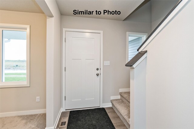 25087 Bluebird Cir, Adel, IA 50003 - entrance foyer featuring baseboards, stairs, and wood finished floors