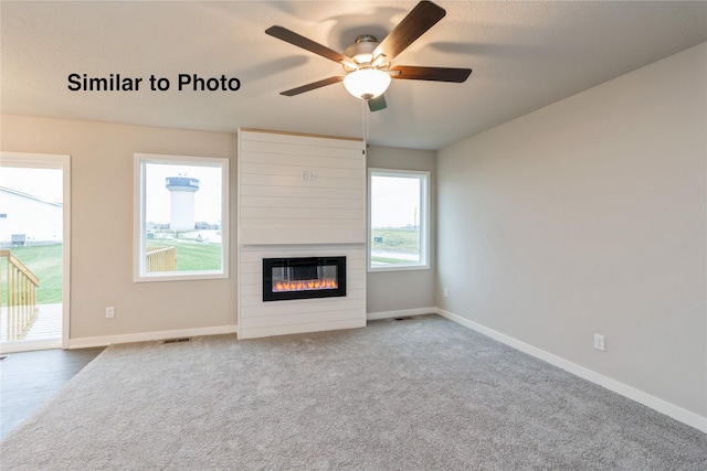 25087 Bluebird Cir, Adel, IA 50003 - unfurnished living room featuring ceiling fan, a large fireplace, baseboards, and carpet flooring