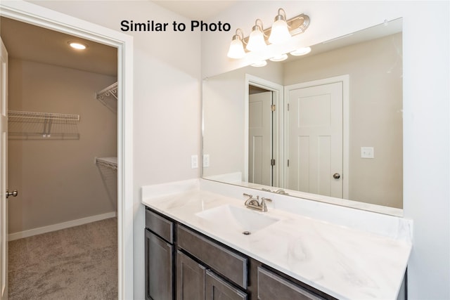 25087 Bluebird Cir, Adel, IA 50003 - bathroom featuring vanity, a spacious closet, and baseboards