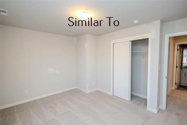 25087 Bluebird Cir, Adel, IA 50003 - unfurnished bedroom featuring light carpet, a closet, and baseboards