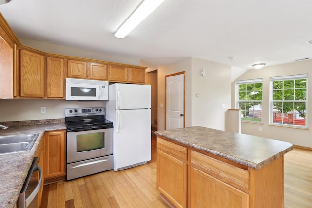 15203 Greenbelt Dr, Urbandale, IA 50323 - kitchen featuring stainless steel appliances, a sink, light wood finished floors, and a center island
