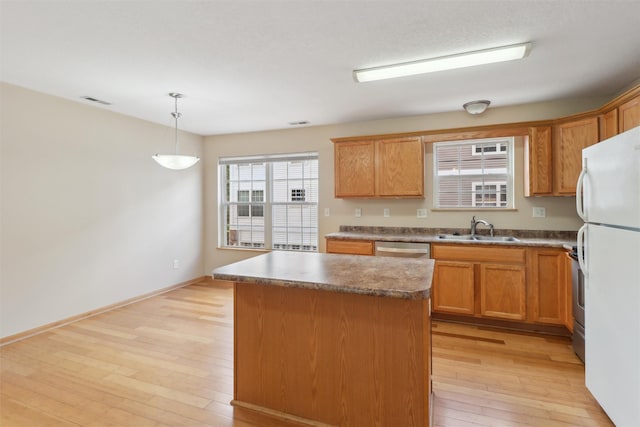 15203 Greenbelt Dr, Urbandale, IA 50323 - kitchen with a sink, freestanding refrigerator, light wood-style floors, a kitchen island, and stainless steel dishwasher