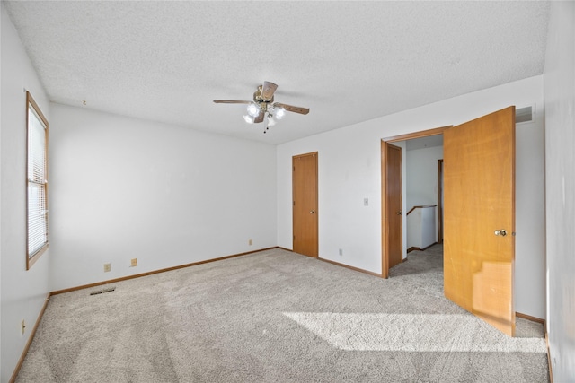 8532 Oakwood Dr, Urbandale, IA 50322 - unfurnished bedroom featuring carpet, a textured ceiling, baseboards, and ceiling fan