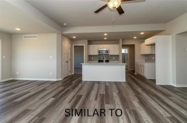 926 Willow Valley Dr, Norwalk, IA 50211 - kitchen featuring stainless steel microwave, ceiling fan, decorative backsplash, baseboards, and dark wood finished floors