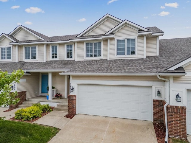 9812 Green View Ln, Johnston, IA 50131 - townhome / multi-family property featuring driveway, a shingled roof, and a garage