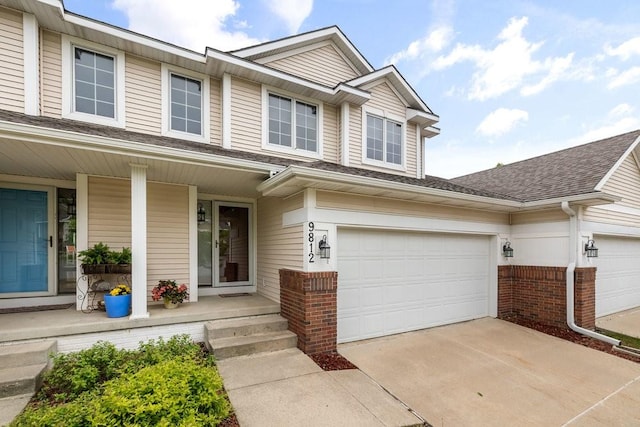 9812 Green View Ln, Johnston, IA 50131 - view of front of house with brick siding, covered porch, driveway, and a shingled roof