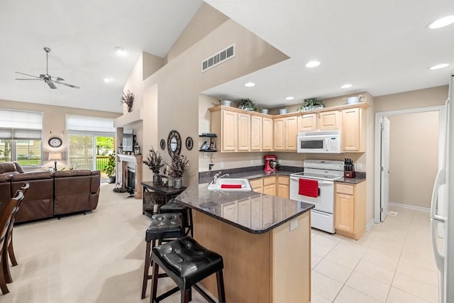 9812 Green View Ln, Johnston, IA 50131 - kitchen featuring white appliances, light brown cabinets, open floor plan, ceiling fan, and a peninsula