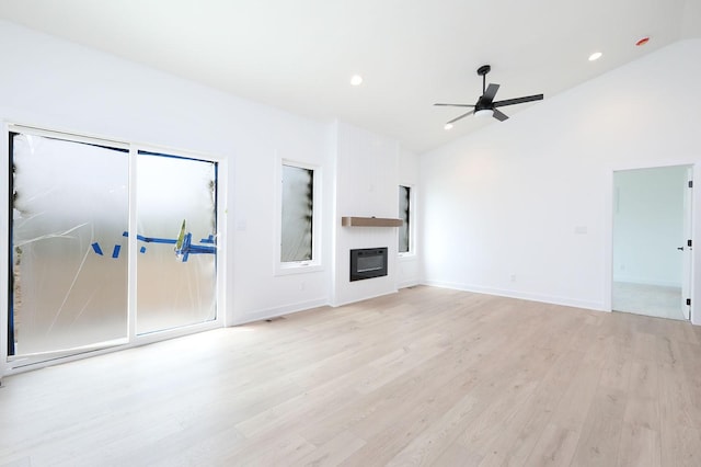 2500 NE 6th St, Grimes, IA 50111 - unfurnished living room with light wood-type flooring, ceiling fan, lofted ceiling, a large fireplace, and recessed lighting