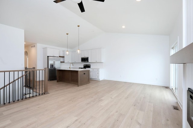 2500 NE 6th St, Grimes, IA 50111 - kitchen with appliances with stainless steel finishes, ceiling fan, light countertops, high vaulted ceiling, and arched walkways