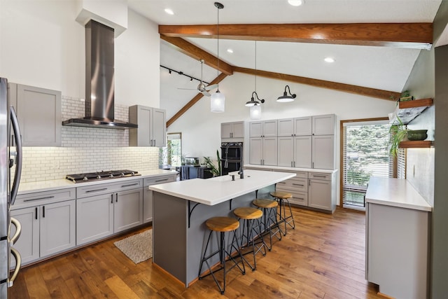 6935 NW 88th Ave, Johnston, IA 50131 - kitchen with wall chimney range hood, gray cabinets, stainless steel appliances, a breakfast bar, and beamed ceiling