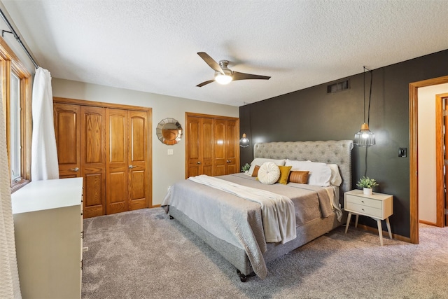 6935 NW 88th Ave, Johnston, IA 50131 - bedroom with two closets, light colored carpet, a textured ceiling, and ceiling fan