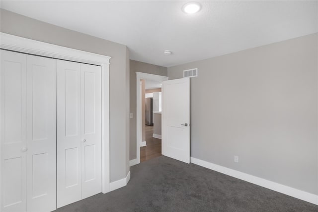501 Kirkwood Ave, Des Moines, IA 50315 - unfurnished bedroom with dark carpet, baseboards, and a closet