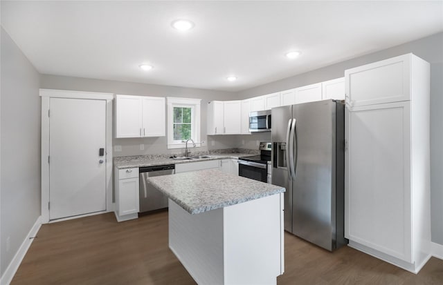 501 Kirkwood Ave, Des Moines, IA 50315 - kitchen featuring appliances with stainless steel finishes, a sink, wood finished floors, light countertops, and white cabinets