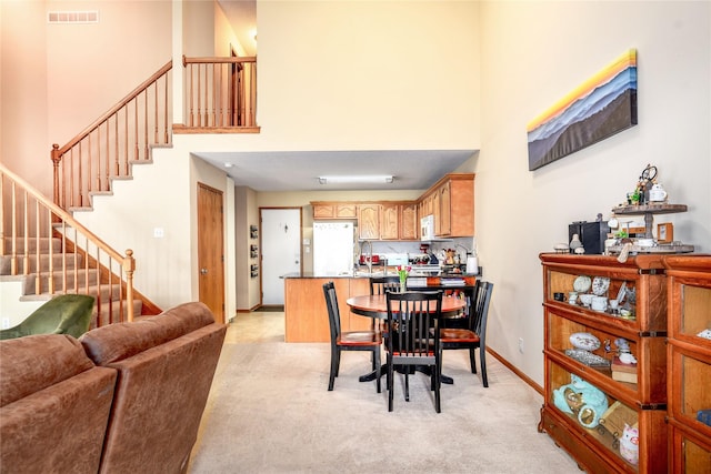2816 Ashland Ct, Altoona, IA 50009 - dining space with a towering ceiling, light carpet, and stairway