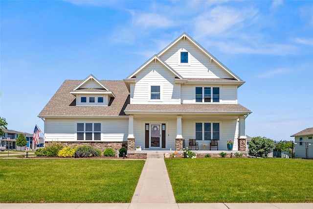 7305 NW 18th St, Ankeny, IA 50023 - craftsman-style home with covered porch, a front yard, a shingled roof, and stone siding