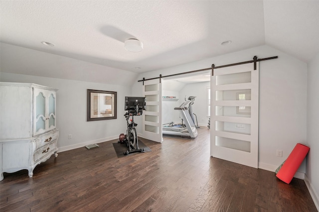 7305 NW 18th St, Ankeny, IA 50023 - exercise room with a barn door, lofted ceiling, dark wood-style floors, baseboards, and a textured ceiling
