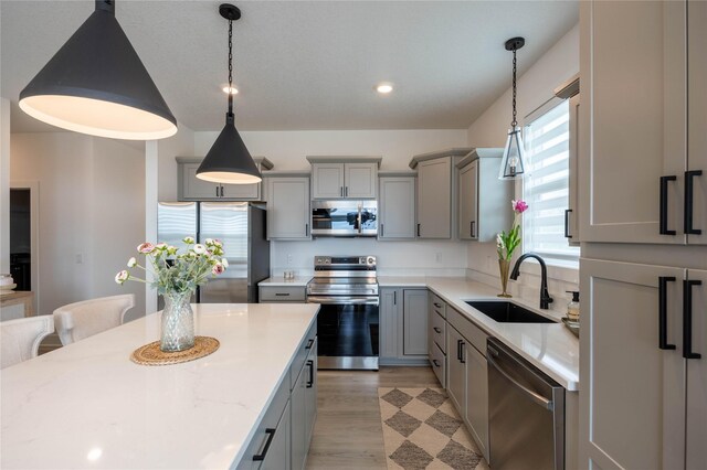 523 NE Vista Ln, Ankeny, IA 50021 - kitchen with appliances with stainless steel finishes, gray cabinets, a sink, hanging light fixtures, and recessed lighting