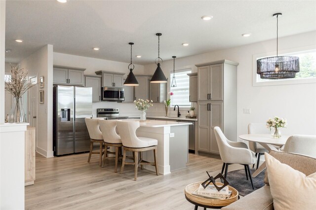 523 NE Vista Ln, Ankeny, IA 50021 - kitchen featuring appliances with stainless steel finishes, gray cabinetry, a center island, a breakfast bar, and recessed lighting