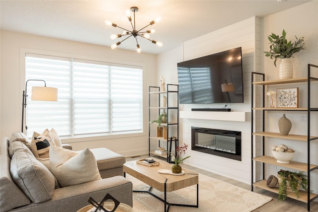 523 NE Vista Ln, Ankeny, IA 50021 - living area featuring a chandelier, wood finished floors, a glass covered fireplace, and baseboards