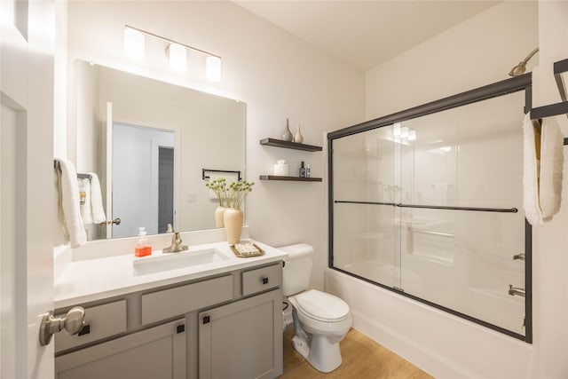 523 NE Vista Ln, Ankeny, IA 50021 - bathroom featuring toilet, wood finished floors, vanity, and shower / bath combination with glass door