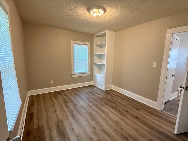 3916 Cambridge St, Des Moines, IA 50313 - unfurnished room featuring a textured ceiling, dark wood-style flooring, and baseboards