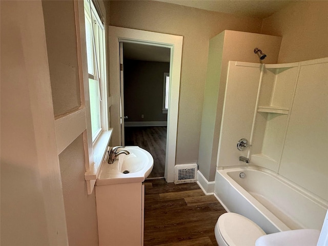 3916 Cambridge St, Des Moines, IA 50313 - full bath featuring wood finished floors, vanity, toilet, and shower / bath combination