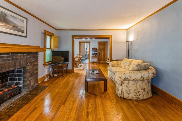 1518 45th St, Des Moines, IA 50311 - living area featuring hardwood / wood-style flooring, crown molding, a brick fireplace, a textured ceiling, and baseboards