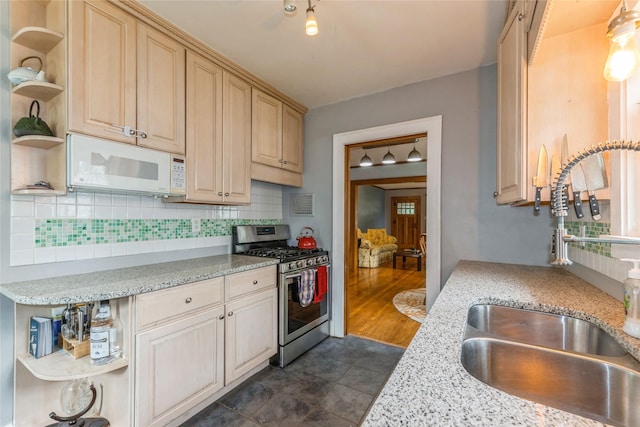 1518 45th St, Des Moines, IA 50311 - kitchen with open shelves, stainless steel range with gas stovetop, white microwave, a sink, and backsplash