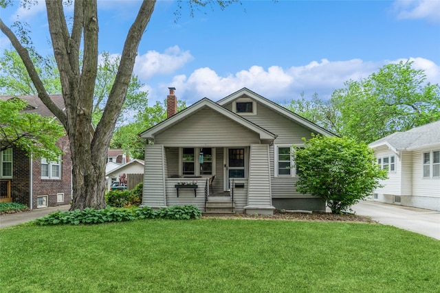 1518 45th St, Des Moines, IA 50311 - bungalow-style home with a chimney, a front yard, a porch, and concrete driveway