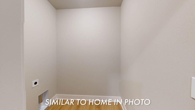 2540 E 50th Ct, Des Moines, IA 50317 - washroom featuring electric dryer hookup, baseboards, and wood finished floors