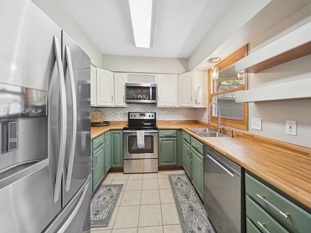 5180 NW 64th Pl, Johnston, IA 50131 - kitchen featuring stainless steel appliances, green cabinets, a sink, wooden counters, and white cabinets