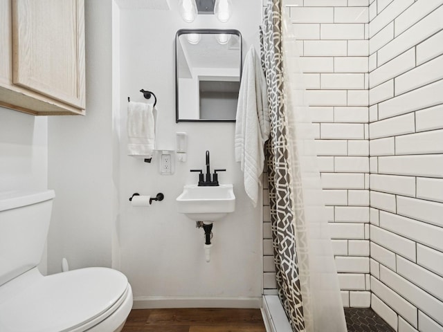 5180 NW 64th Pl, Johnston, IA 50131 - bathroom featuring wood finished floors, toilet, baseboards, curtained shower, and a sink