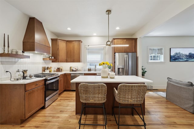 1107 24th St, Des Moines, IA 50311 - kitchen with appliances with stainless steel finishes, premium range hood, backsplash, a breakfast bar, and a kitchen island