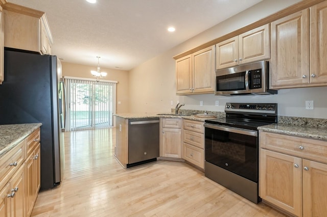 1960 NW 126th St, Clive, IA 50325 - kitchen with appliances with stainless steel finishes, light brown cabinets, light wood-type flooring, a sink, and a peninsula