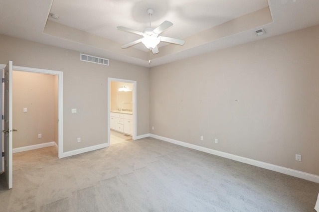 1960 NW 126th St, Clive, IA 50325 - unfurnished bedroom featuring a raised ceiling, light carpet, baseboards, ensuite bath, and a ceiling fan