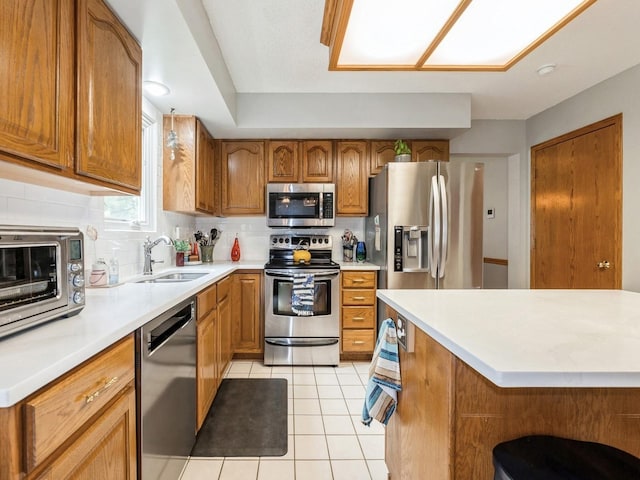 2190 NW 147th St, Clive, IA 50325 - kitchen with appliances with stainless steel finishes, a sink, brown cabinets, decorative backsplash, and light countertops