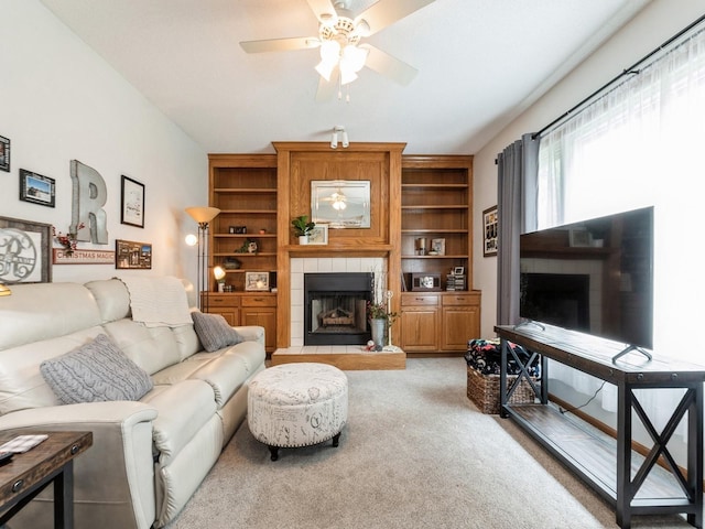 2190 NW 147th St, Clive, IA 50325 - living room featuring a tiled fireplace, ceiling fan, light carpet, and built in shelves